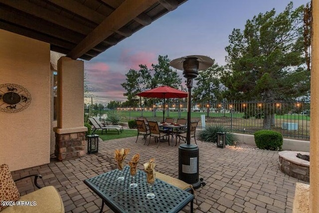 patio terrace at dusk with outdoor dining area and fence