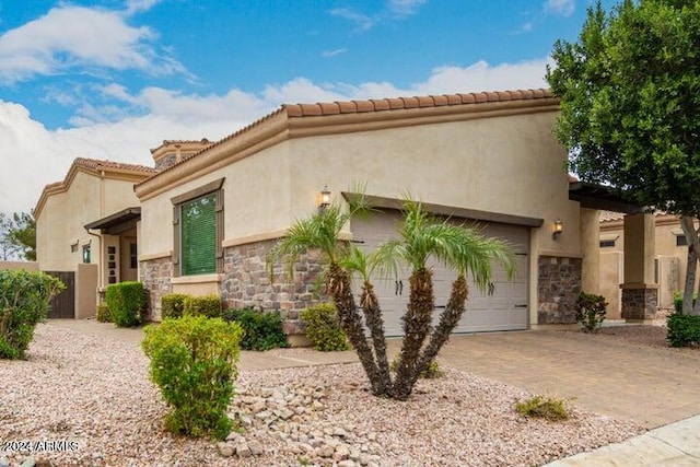 view of front facade featuring stone siding, decorative driveway, an attached garage, and stucco siding