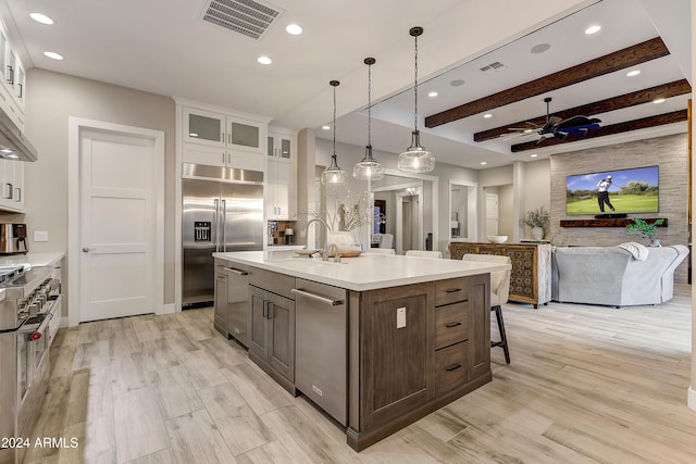 kitchen with white cabinetry, ceiling fan, an island with sink, and stainless steel appliances