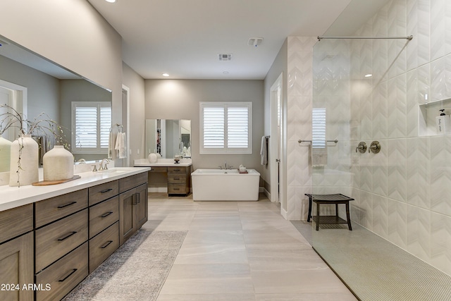 bathroom featuring a wealth of natural light, tile patterned flooring, vanity, and plus walk in shower