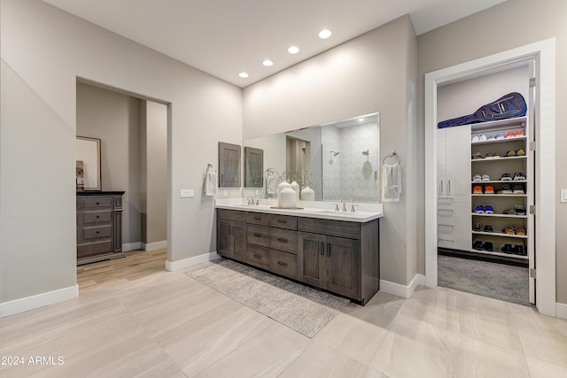 bathroom with tile patterned flooring, vanity, and walk in shower