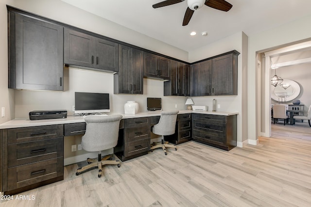 office area featuring ceiling fan, built in desk, and light wood-type flooring