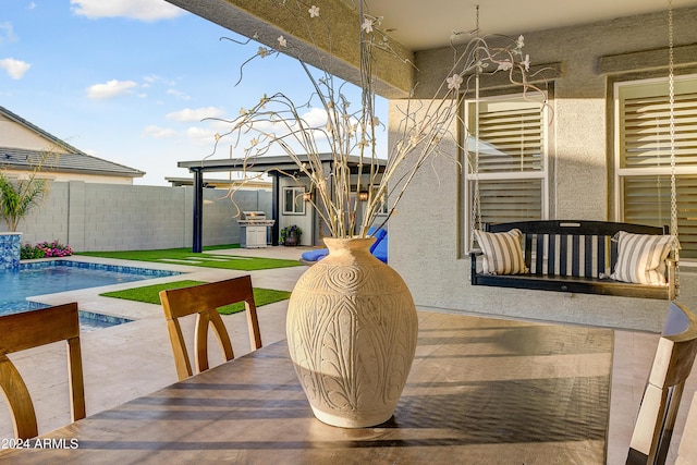 exterior space with a fenced in pool and grilling area