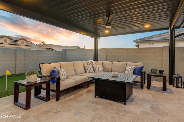 patio terrace at dusk featuring an outdoor living space and ceiling fan