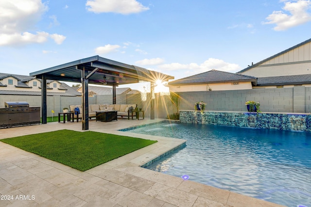 view of pool with an outdoor hangout area, pool water feature, grilling area, a patio area, and a lawn