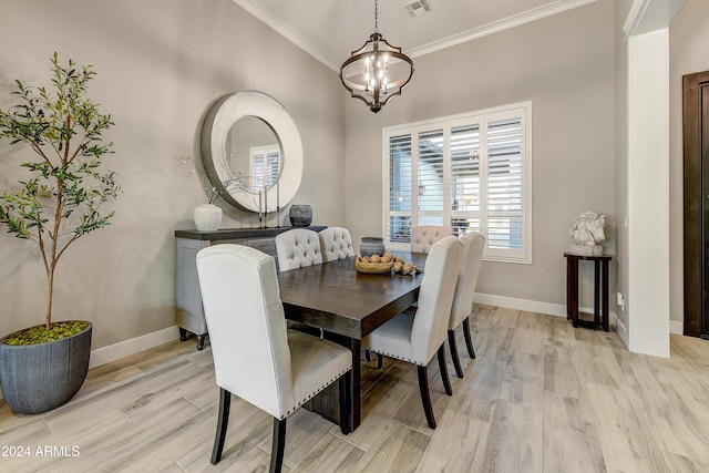 dining room with an inviting chandelier, ornamental molding, and light wood-type flooring