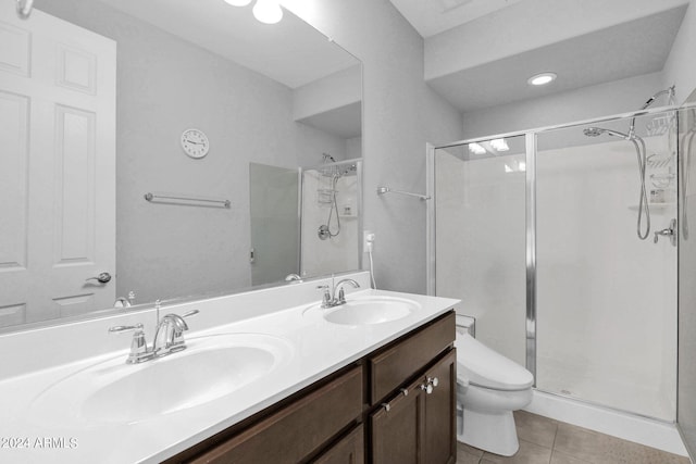 bathroom with tile patterned floors, a shower with door, vanity, and toilet