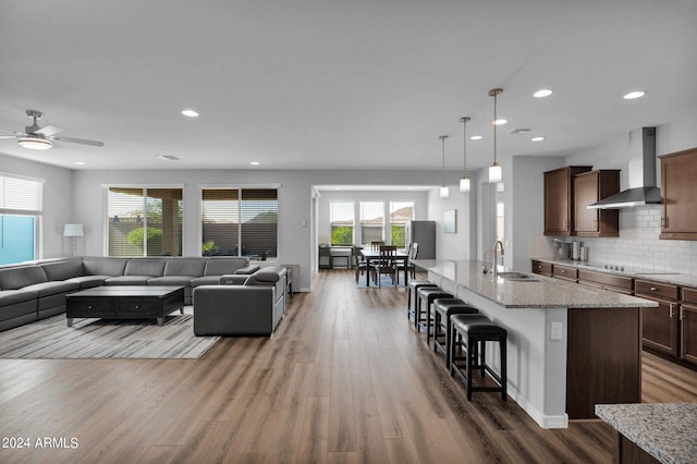 living room featuring ceiling fan, hardwood / wood-style floors, and sink