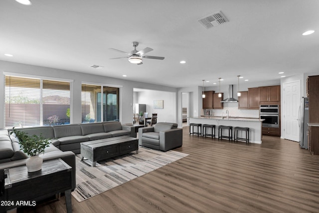 living room with ceiling fan, dark wood-type flooring, and sink