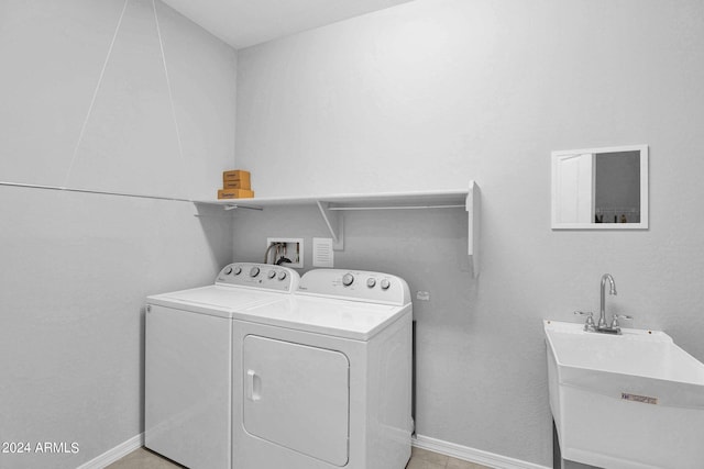 washroom with light tile patterned flooring, sink, and washing machine and clothes dryer