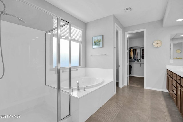 bathroom featuring independent shower and bath, vanity, and tile patterned floors