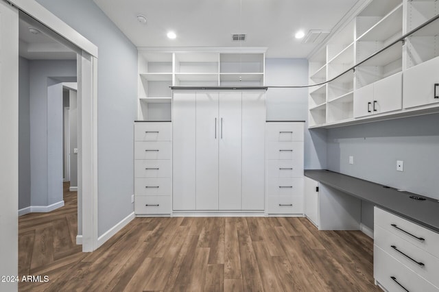 walk in closet with dark hardwood / wood-style floors