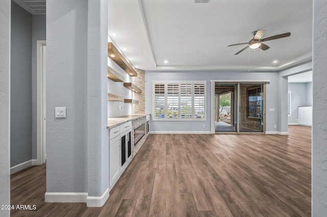 kitchen featuring white cabinets, a tray ceiling, ceiling fan, and dark hardwood / wood-style floors