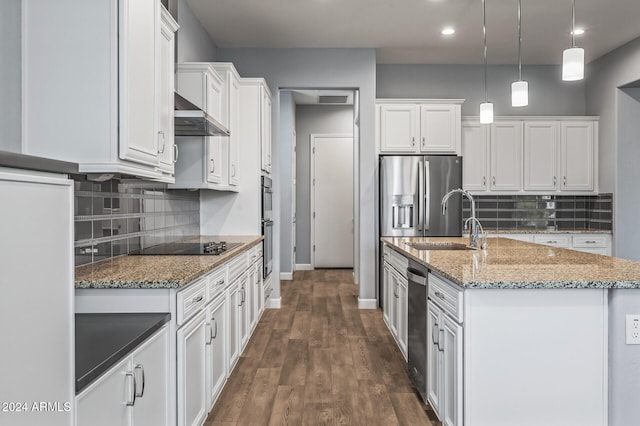 kitchen featuring pendant lighting, sink, stainless steel fridge, an island with sink, and white cabinetry