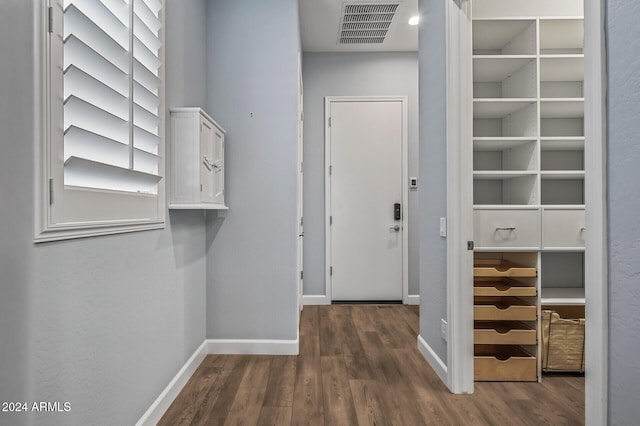 spacious closet with dark hardwood / wood-style flooring