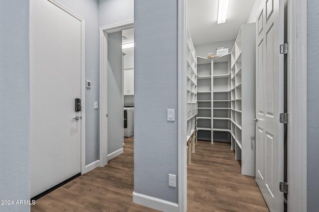 spacious closet with washer / clothes dryer and dark wood-type flooring