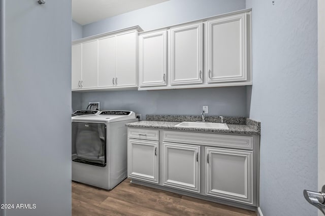 laundry area featuring cabinets, dark hardwood / wood-style floors, washer / dryer, and sink