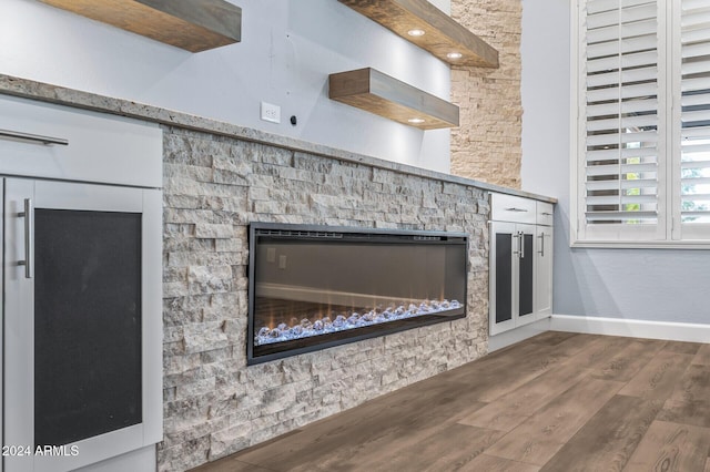 interior details featuring hardwood / wood-style floors and a stone fireplace