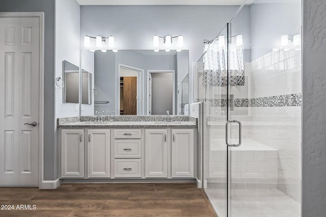 bathroom featuring hardwood / wood-style floors, vanity, and a shower with door