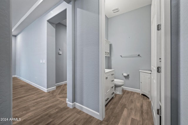 bathroom with wood-type flooring, vanity, and toilet