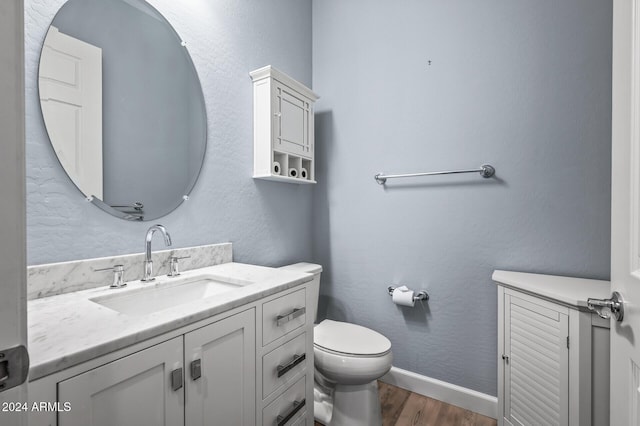 bathroom featuring wood-type flooring, vanity, and toilet