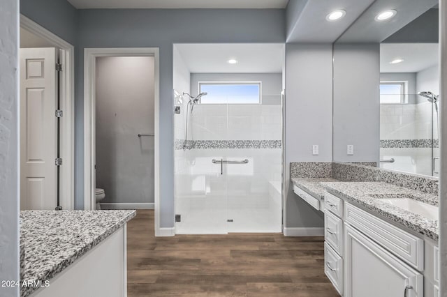 bathroom featuring toilet, hardwood / wood-style flooring, plenty of natural light, and an enclosed shower