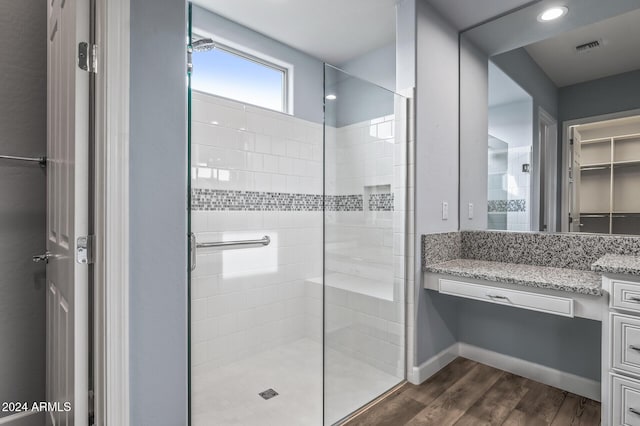 bathroom featuring hardwood / wood-style floors, vanity, and a shower with door