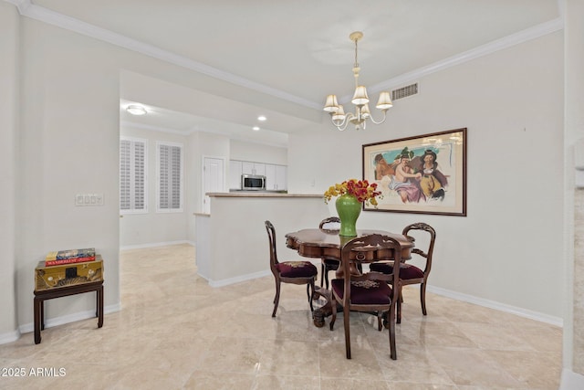 dining area with crown molding and an inviting chandelier