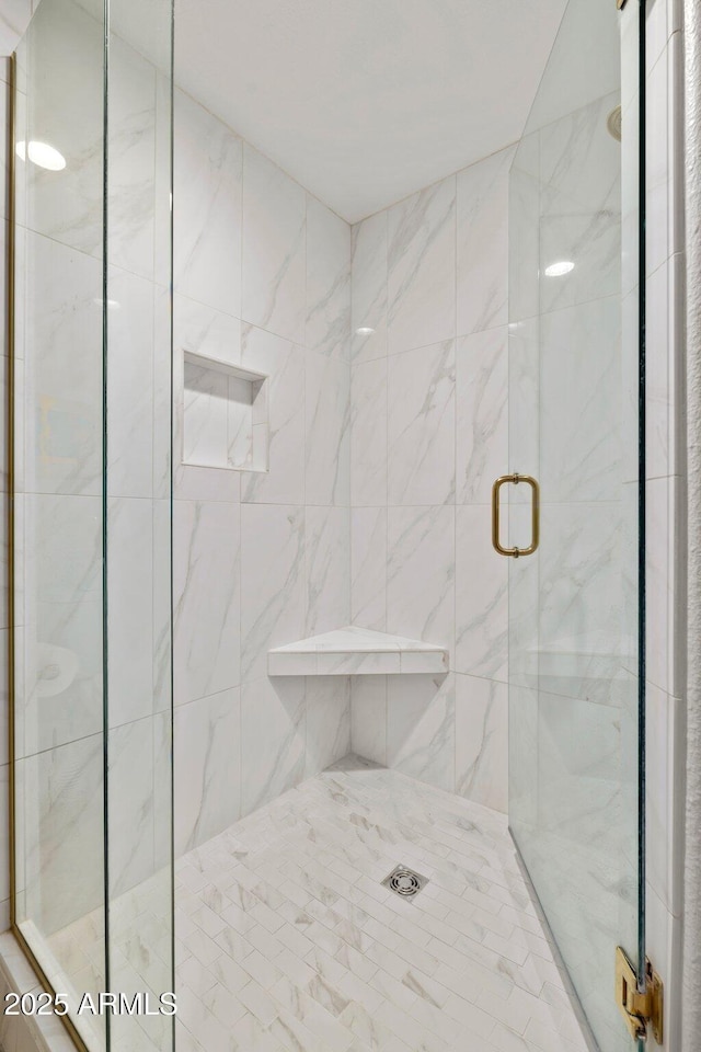 bathroom featuring a shower with shower door