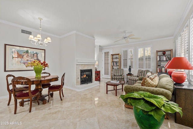 living room with ceiling fan with notable chandelier, ornamental molding, and a multi sided fireplace