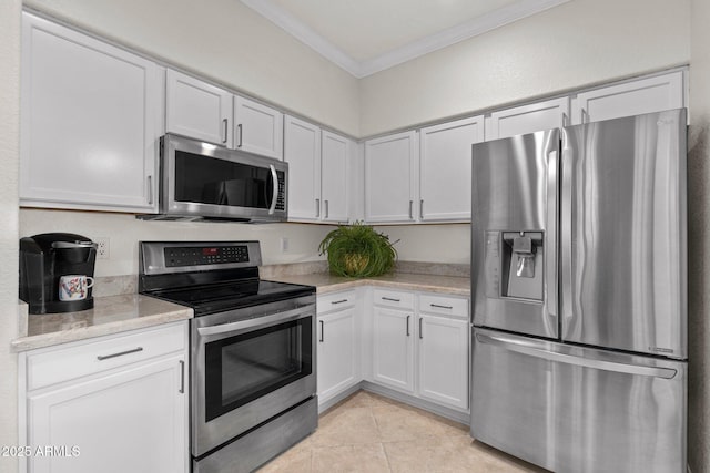 kitchen with ornamental molding, appliances with stainless steel finishes, and white cabinets