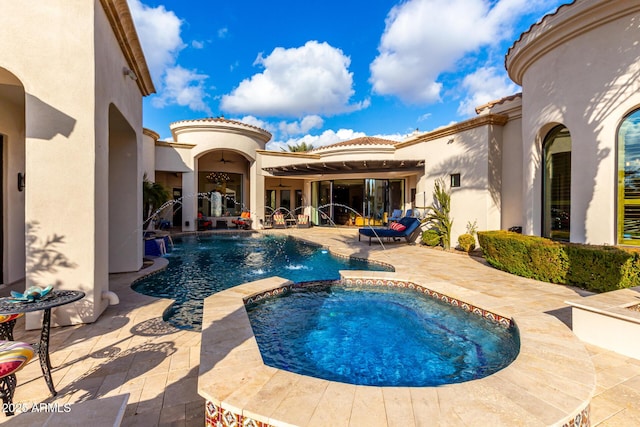 view of swimming pool featuring an in ground hot tub, pool water feature, and a patio