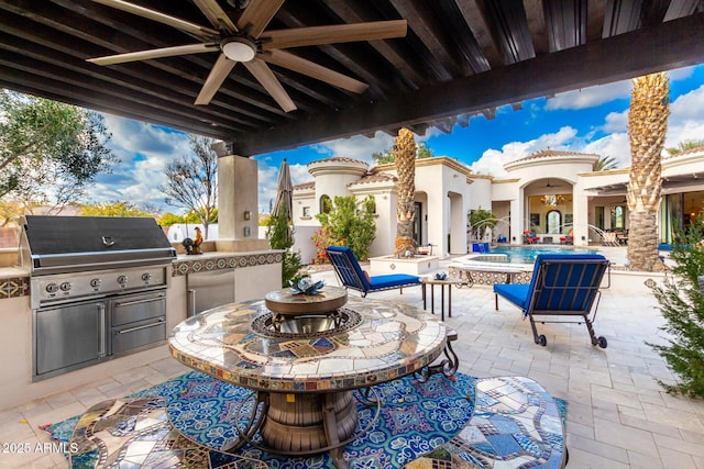 view of patio with a grill, exterior bar, area for grilling, and ceiling fan