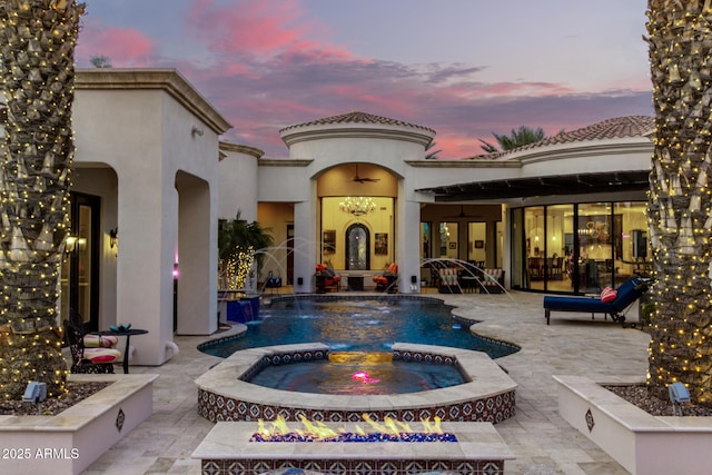 exterior space featuring a patio area, pool water feature, and an in ground hot tub