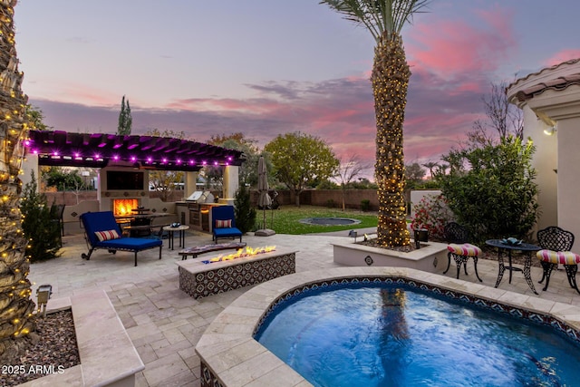 pool at dusk featuring an outdoor fire pit, a hot tub, and a patio