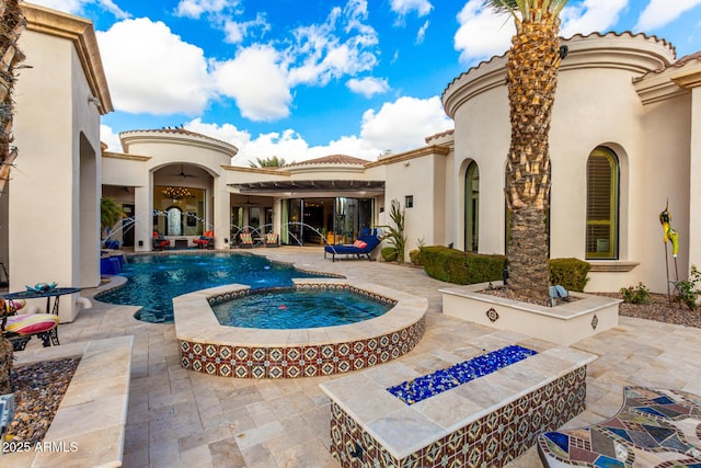 view of swimming pool with an in ground hot tub, pool water feature, a fire pit, and a patio