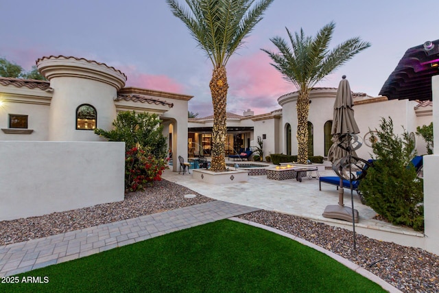 patio terrace at dusk featuring an outdoor fire pit