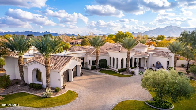 mediterranean / spanish home with a garage and a mountain view