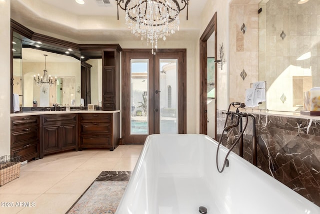 bathroom featuring a bathtub, a chandelier, vanity, tile patterned floors, and french doors