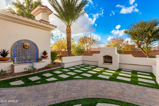 view of yard featuring a patio area and an outdoor fireplace