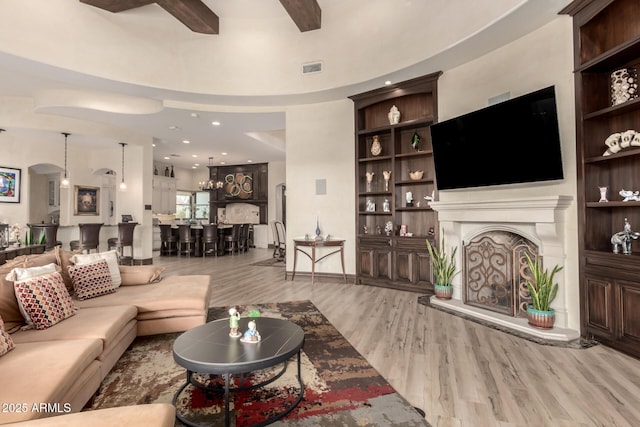 living room featuring built in features and light hardwood / wood-style floors