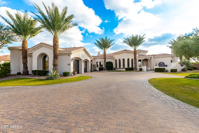 mediterranean / spanish home with a garage and a front lawn