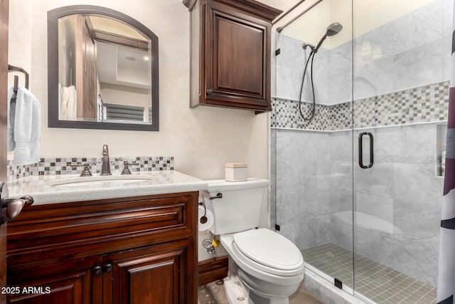 bathroom featuring vanity, toilet, an enclosed shower, and decorative backsplash