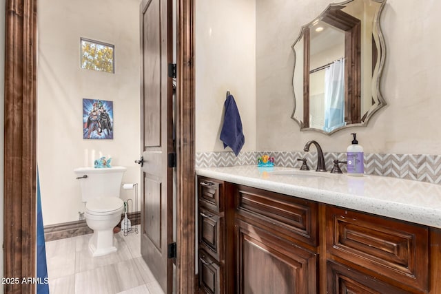 bathroom with vanity, backsplash, and toilet