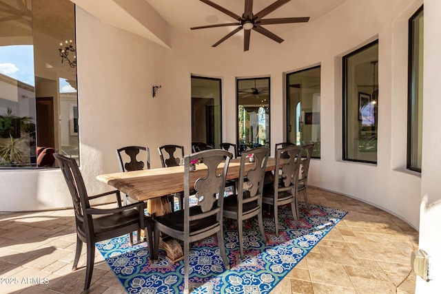 dining space with ceiling fan with notable chandelier