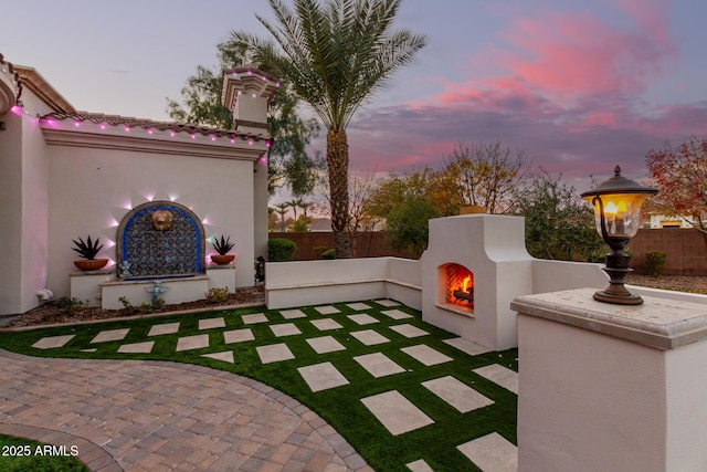 patio terrace at dusk with exterior fireplace