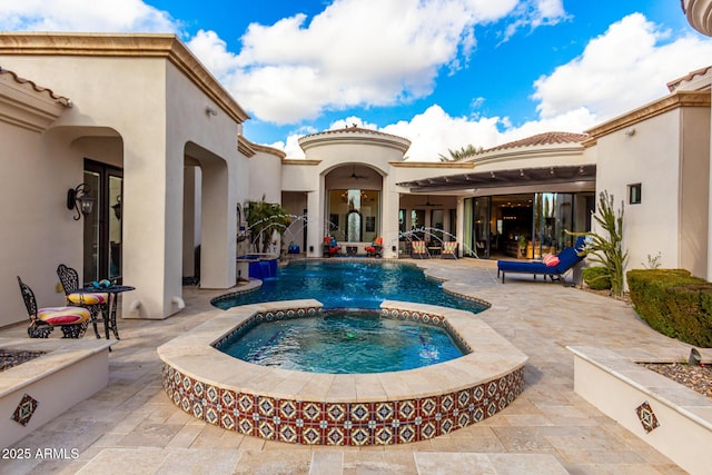 view of pool with an in ground hot tub, pool water feature, and a patio