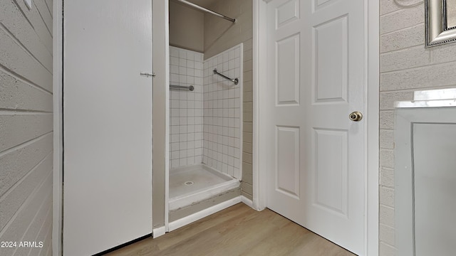 bathroom featuring tiled shower and hardwood / wood-style flooring