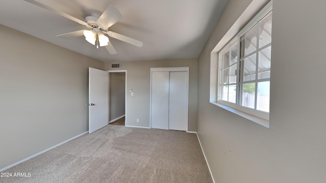 unfurnished bedroom with ceiling fan, a closet, and light colored carpet