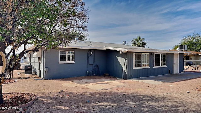 rear view of property with central AC unit and a patio